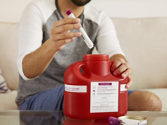 Person disposing a used HUMIRA Pen or syringe.